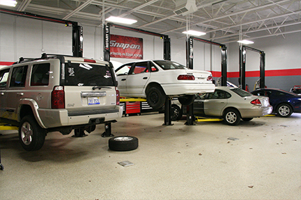 four lifts with vehicles in shop