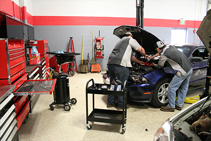 students changing oil on car