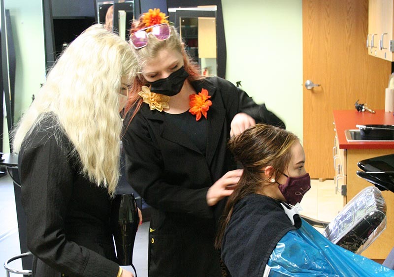 Cosmetology instructor showing hair drying technique