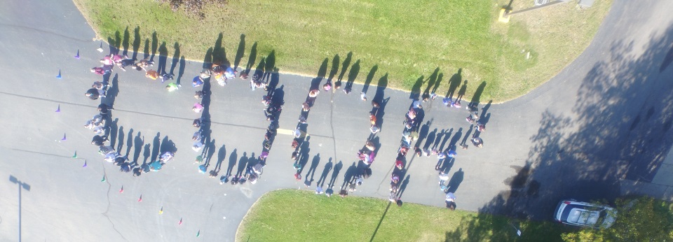 aerial photo of students outside the school building, in formation to spell COOR
