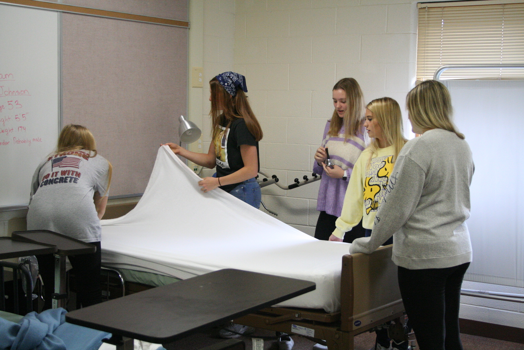Medical Occupations students learning how to make a hospital bed