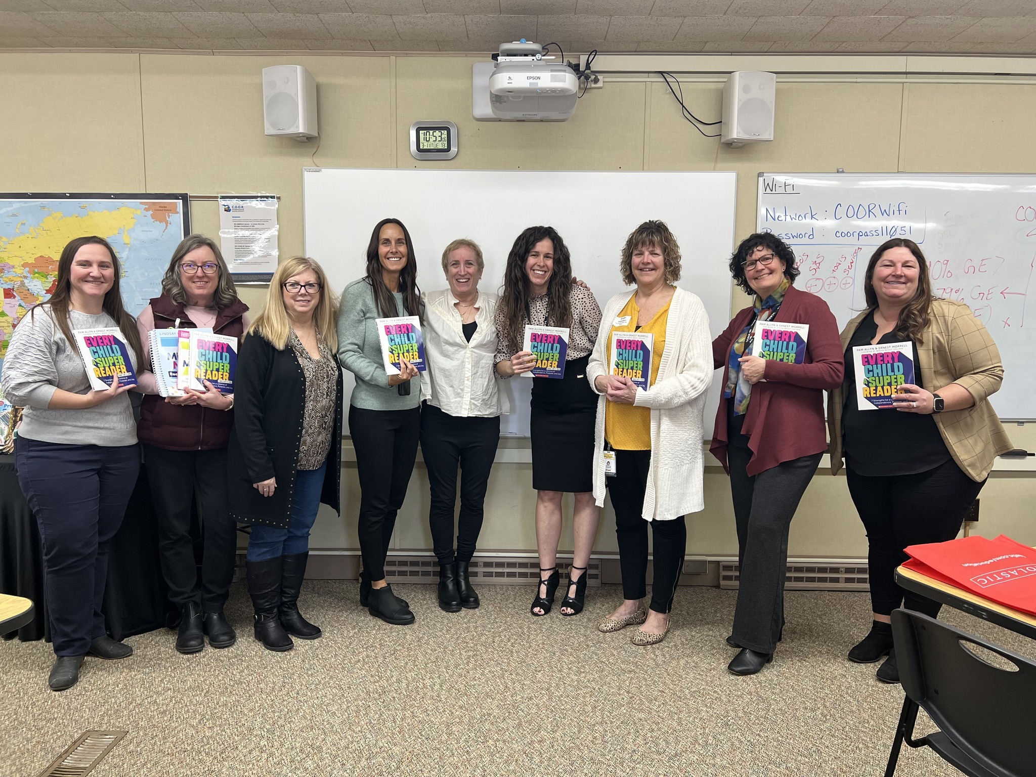 Image of people holding a book Every Child Super Reader